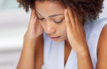 Stressed Afro-American woman suffering from headache.