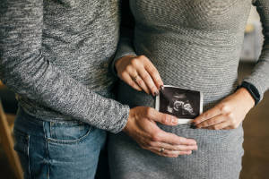 a couple holding ultrasound scan of baby